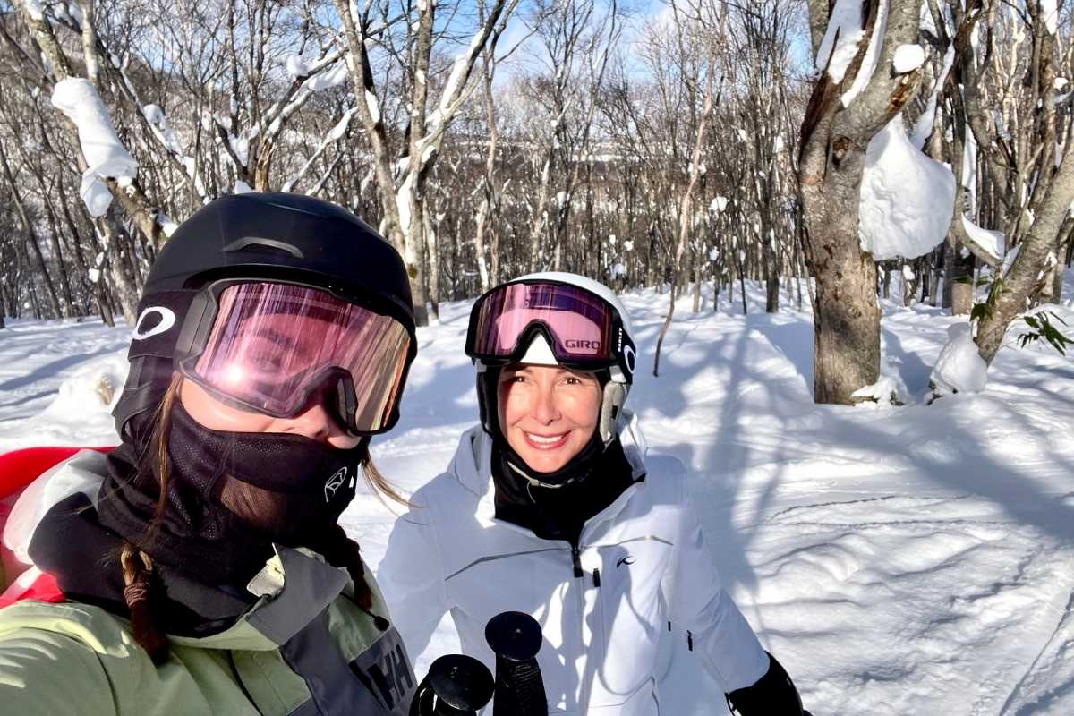 Claudia Hackman and her daughter standing outside Park Hyatt Niseko in winter with snow.