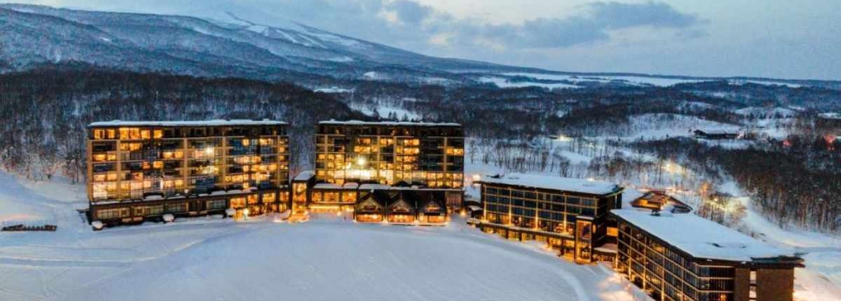 Park Hyatt Niseko Hotel illuminated with lights and blanketed in snow during the winter season.