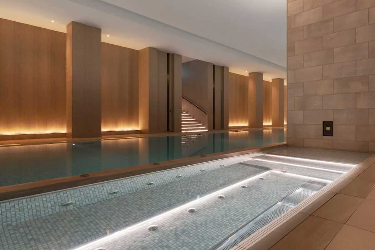 A luxurious indoor swimming pool at Park Hyatt Niseko, surrounded by elegant design and warm lighting.